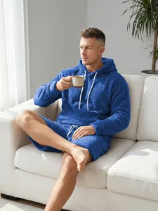 Mannelijk model ontspant op de bank in een blauwe koraalvlies loungewear set voor comfort.