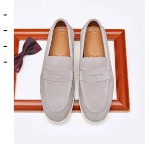 Detailed overhead view of men's grey suede loafers featuring elegant moccasin stitching details