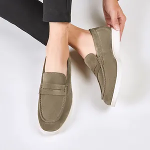 Stylish olive green suede men's loafers with white sole on model