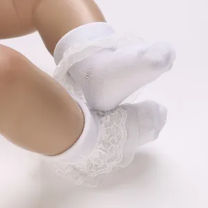 Detail view of white infant socks with elegant ruffled lace for 0-1 year old babies.