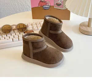 Close-up of children's warm brown snow boots with thick fleece lining on desk