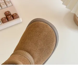 Close-up detail of warm brown suede children's snow boots with durable stitching
