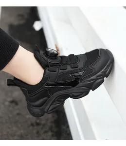 Detailed side view of black breathable sneakers for boys with rotary buckle closure