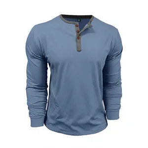 Detail of a blue cotton long-sleeved Henley T-shirt with grey contrast button placket.