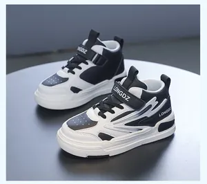 Baskets mi-hautes pour enfants en noir et blanc avec dessus en similicuir résistant.