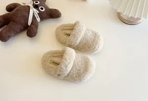 Nahaufnahme gemütlicher cremefarbener Kinder-Hausschuhe mit weichem Plüsch für den Winter.