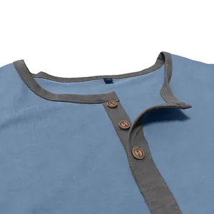 Close-up detail of a blue cotton Henley shirt collar with grey trim and three buttons.