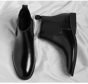Macro detail of classic men's black leather Chelsea boots on elegant white silk background