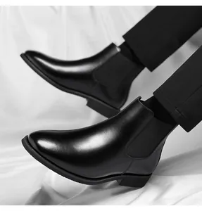 Detail of black leather Chelsea boots with elastic side panels and sleek pointed toe.