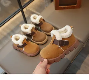 Gros plan de bottes d'hiver chaudes pour filles avec doublure en polaire et boucle décorative.