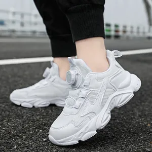 Breathable white boys chunky sneakers with rotating buckle lace on urban asphalt road