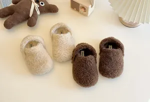 Nahaufnahme von flauschigen Fleece-Hausschuhen für Kinder in Off-White und Braun