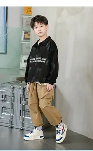 Garçon posant avec des baskets mi-hautes en cuir durable, look décontracté complet.