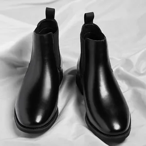 Classic black leather Chelsea boots for men shown from a high angle on silk background