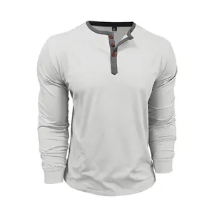 Close-up of a white cotton long-sleeved Henley shirt featuring orange button detail