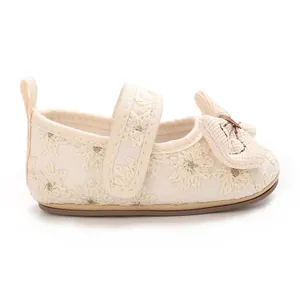 Detaillierte Seitenansicht beiger Baby-Lauflernschuhe mit Stickerei und Schleife