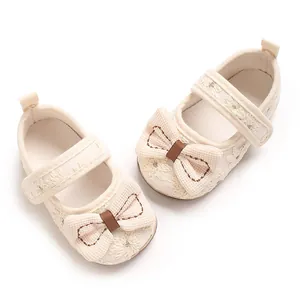 Detailansicht der niedlichen cremefarbenen Baby-Prinzessinenschuhe mit Schleife