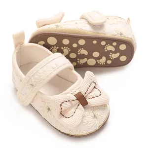 Detailansicht cremefarbener Baby-Prinzessinnenschuhe mit floraler Stickerei und Sohle.