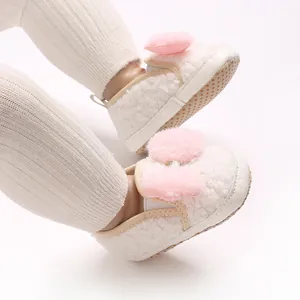 Close-up of baby girl fleece crib shoes with cute pink plush bow detail