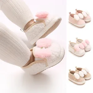 Detail view of cute baby girl crib shoes with soft pompoms and non-slip soles