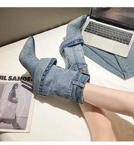 Detail view of denim pointed-toe stiletto boots with unique fold-over pant-leg design
