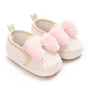 Adorable white fleece baby girl crib shoes featuring pink fluffy bow and soft anti-slip sole