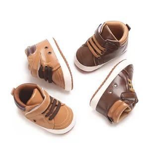 Vista dall'alto di sneakers alte da neonato in PU marrone chiaro e scuro con velcro.