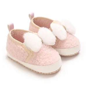 Detailed view of cute pink fuzzy infant crib shoes featuring large white fluffy bows