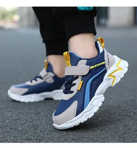 Vista lateral de zapatillas de deporte ligeras para niños en azul marino y gris.