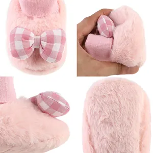 Close-up detail of pink plush baby shoes with a gingham bow and soft texture
