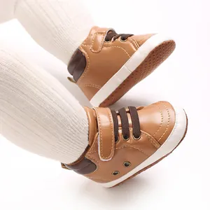 Dettaglio ravvicinato di scarpe alte da neonato in ecopelle marrone con suola antiscivolo