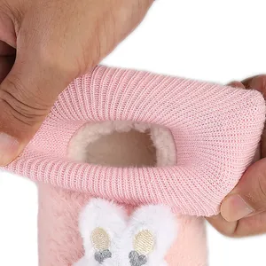 Macro detail of pink plush baby bootie showing warm fleece lining and elastic cuff