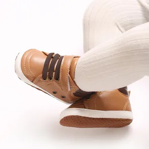 Dettaglio di sneakers alte in pelle PU marrone per neonati con suola in tessuto antiscivolo