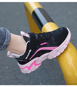 Vista detallada de zapatillas deportivas para niños en negro y rosa con suela gruesa.