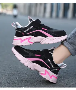 Elegantes zapatillas de correr para niños en negro y rosa en una vista de estilo exterior.