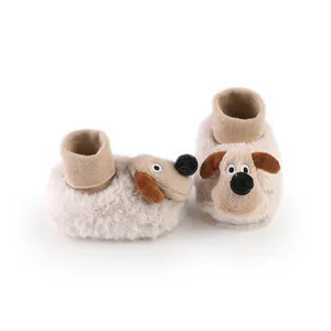 Detail view of cute plush baby booties with cartoon dog design and warm fleece lining
