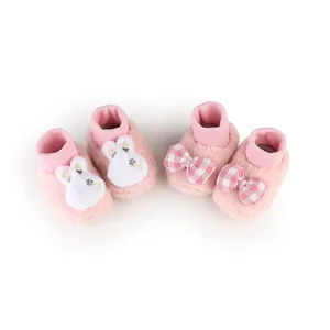 Close-up view of pink plush baby walker shoes featuring bunny and checkered bow