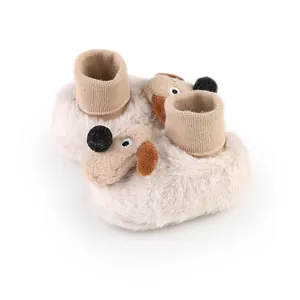 Close-up of baby winter plush booties with cute dog motif and knit ankle cuffs