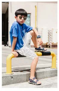 Detaillierte Outdoor Lifestyle Aufnahme eines Jungen in stilvollen blauen Sandalen.