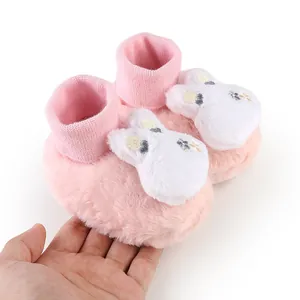 Close-up of plush pink baby booties with cute rabbit ears and soft knit cuffs
