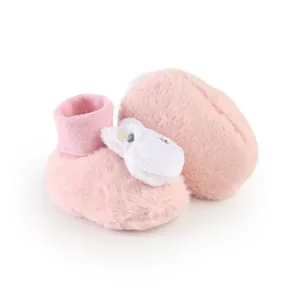 Close-up of soft pink plush baby booties with a cute white cartoon animal head