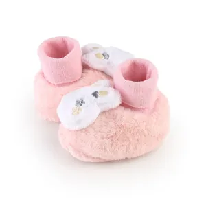 Detailed view of pink furry baby walking shoes featuring cute white bunny ears decor