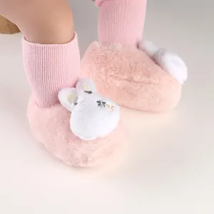 Close-up detail of soft pink fluffy baby winter booties with cute rabbit ear design