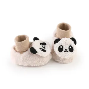 Detailweergave van pluche panda baby loopschoentjes met zachte gebreide boorden.