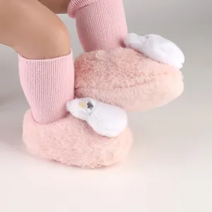 Soft pink plush baby winter shoes with cute white bunny ear decorations for toddlers.