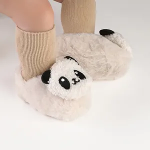 Close-up van pluizige babyloopschoentjes met schattig pandagezicht voor de winterperiode.