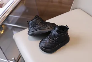 Detalle de botas de nieve acolchadas negras para niños pequeños con forro cálido