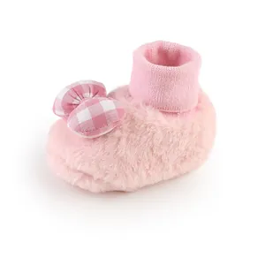 Detail view of pink plush baby floor shoe with checkered bow for newborn girls