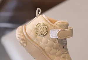 Detalle de bota de nieve acolchada para niños con forro cálido de piel sintética y velcro.
