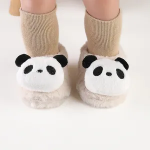 Detailopname van schattige pluche pandapantoffels met gebreide sokken voor baby's in de winter